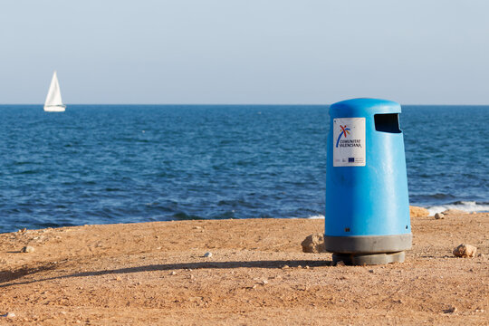 Papelera en la playa de la comunidad valenciana con fondo del mar Mediterr&aacute;neo y velero desenfocado el 8 de abril de 2025 en Alicante, Espa&ntilde;a