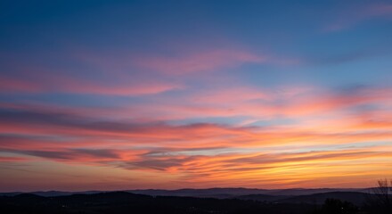 Obraz premium Serene Sunset Landscape - Breathtaking sunset over rolling hills, showcasing vibrant pink, orange, and yellow hues in the sky