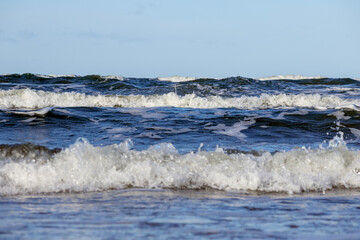 
a wavy body of water under a bright sky.