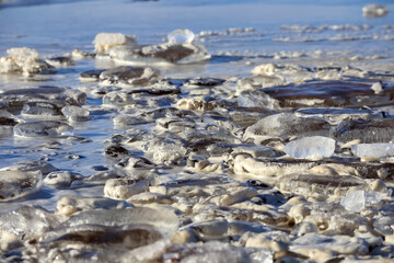 
a partially frozen body of water with many pieces of ice on the surface.