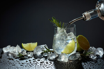 Gin and tonic cocktail made with dry gin, tonic water, lime, and ice.