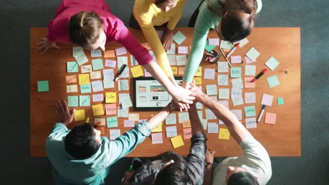 Time lapse of smart developer working on tablet display website wireframe prototype for mobile phone while putting hands together to celebrate successful project. Team making stack of hand. Symposium.