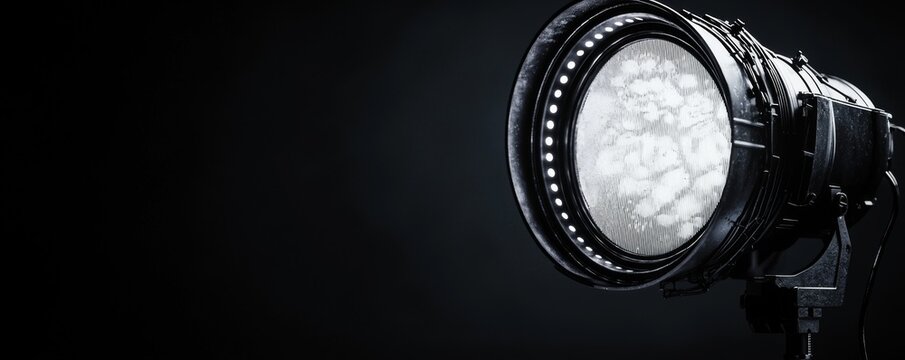 Professional studio light illuminating a dark space, ideal for photography setups.