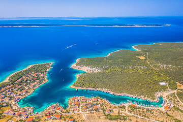 A beautiful aerial view of the small coastal village of Simuni on Pag Island, Croatia, known for its scenic bay, and popular camping tourism set among pine trees and Mediterranean nature