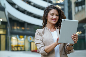 Successful Businesswoman Reading Digital Tablet While Standing Outdoors Near Contemporary Corporate...