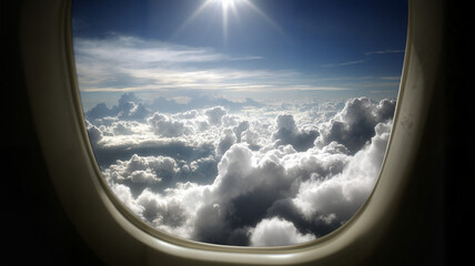 View of Clouds from Airplane Window Under Bright Sunlight  