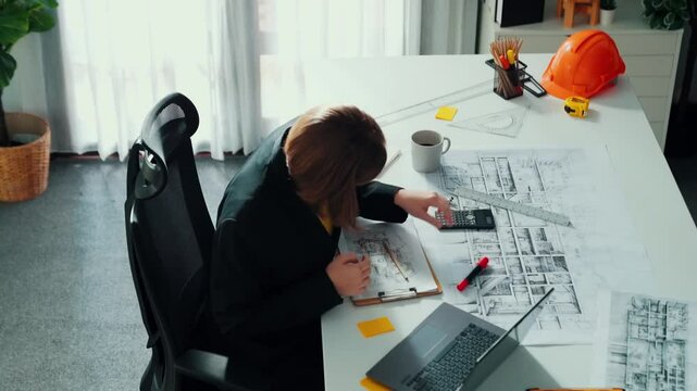 Top view of architect engineer drink coffee and draw blueprint at meeting table with equipment and safety helmet scatter around. Aerial view of project manager looking at project plan. Alimentation.