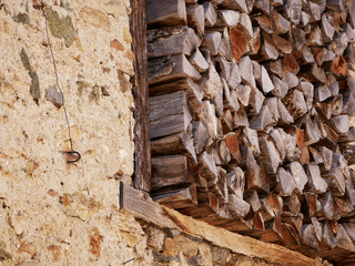 old house wall with stacked dry firewood included