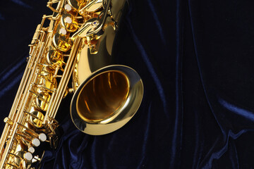 Jazz. One beautiful saxophone on dark blue fabric, top view. Space for text