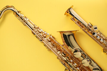 Jazz. Shiny saxophones on yellow background, top view