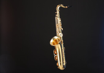 Golden saxophone on black background. Musical instrument