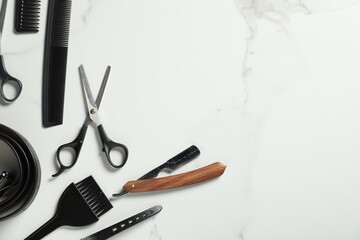 Many different barber's tools on white marble table, flat lay. Space for text