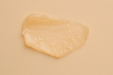 Moisturizing lip balm on beige background, top view