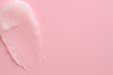 Moisturizing lip balm on pink background, top view. Space for text