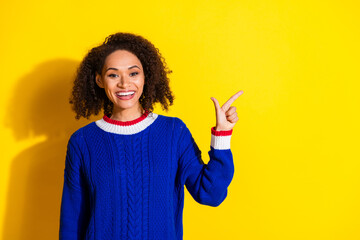 Cheerful young woman posing with positive energy and stylish fashion against a vivid yellow...