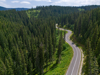 Curve asphalt road on mountain forest summer. Aerial view of the road passing through the mountain and green forest.