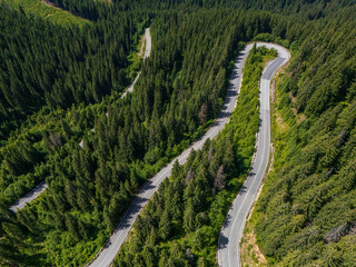 Curve asphalt road on mountain forest summer. Aerial view of the road passing through the mountain and green forest.