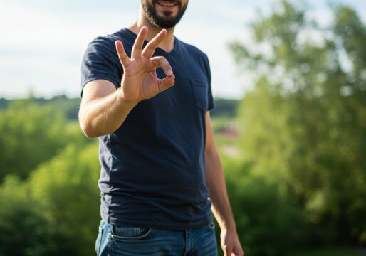 Man shows okay gesture against a nature backdrop to showcase satisfaction, approval, or quality performance visuals for social media, advertising or product review purposes.