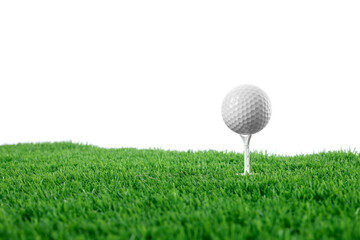 Golf ball, tee and green grass against white background