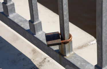 rusty padlock closed on railing