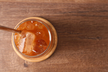 Tasty iced coffee on wooden table, top view. Space for text