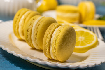 Delicious lemon macarons with lemon slices on white plate