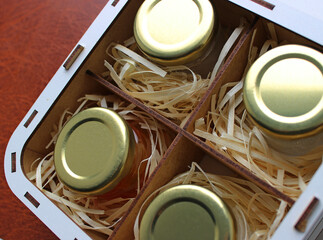 Souvenir from Home Apiary. Set of Different Types of Honey in Identical Jars in a Gift Case on...