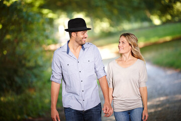 Obraz premium Couple, hand holding and happy with walk in park for love, bonding with care and support in healthy relationship. Man, woman and outdoor for date with romance, trust and commitment for marriage