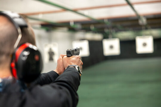 Strzelec. Strzelnica sportowa z tarczami przygotowanymi do strzelania z broni sportowej podczas zawod&oacute;w z pistoletu.