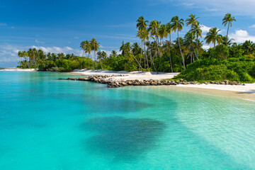 Beautiful tropical beach with white sand, palm trees, turquoise ocean against blue sky with clouds on sunny summer day, island of Maldives.
