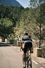 Cyclist riding road bike on scenic mountain road.  Enjoy the stunning view and sense of freedom. Perfect for travel, sports, and adventure themes.