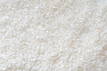 Close-up of uncooked white rice grains, showing clean, natural texture, perfect for food backgrounds, packaging, or culinary design elements.
