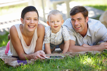Parents, child and happy with tablet, portrait and garden for e learning, development and growth. Man, woman and boy on technology, smiling and educational gaming for motor skills, bonding and family