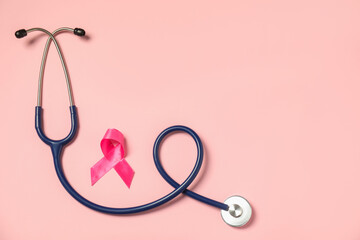 Breast cancer awareness. Pink ribbon and stethoscope on color background, flat lay. Space for text