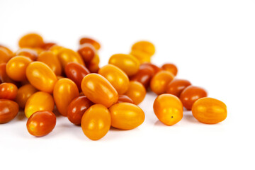 Top view of  fresh yellow and orange cherry tomatoes scattered on white background.   Isolated on clean white backdrop. Food, health, and organic nutrition concepts. Copy space