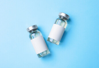 Hepatitis vaccine in glass vials on light blue background, top view