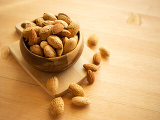 Raw organic whole almonds in a wooden bowl