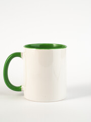 Two-tone 11oz mug on isolated background. Mug with green handle and inner part.
