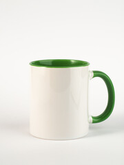 Two-tone 11oz mug on isolated background. Mug with green handle and inner part.