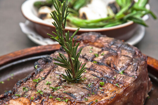 Grilled beef steak with serrano peppers and grilled onions. Delicious beef steak on a grey background, rib eye 800 grs.