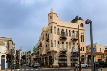 Fototapeta premium Tel Aviv-Jaffa, Israel.Eclectic Historic Building with Arched Windows and Decorative Balconies at the Intersection of Hanina Ben Dosa Street and Yehuda Margoza Street in Flea Market of Old Jaffa,