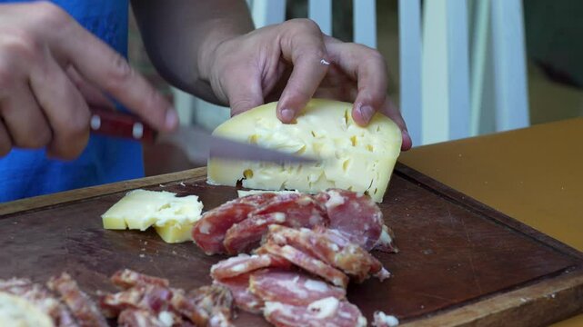 picada de quesos y salamin, mesa de picadas cortando queso, salame, asado, argentino, 