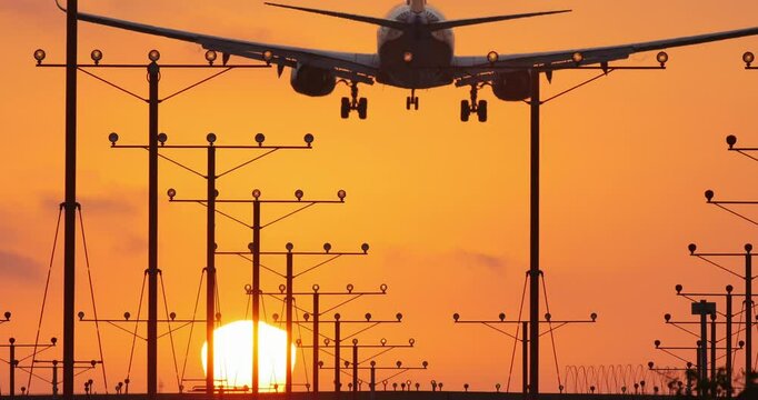 Airplane landing in airport at sunset.
