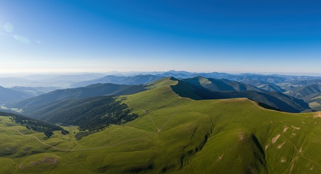 Green mountain range under a clear blue sky aerial view.