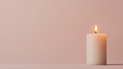 A lit white candle on a soft pink backdrop, creating a serene and calming atmosphere.