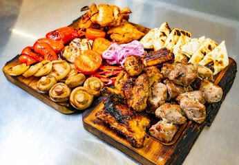 Assorted grilled meats and vegetables on a wooden platter