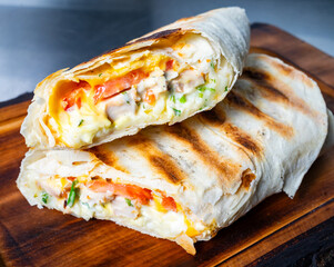 Delicious wrap with grilled chicken and fresh vegetables served warm