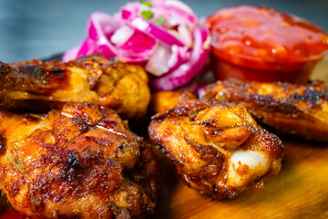 Delicious grilled chicken wings served with onion salad and sauce