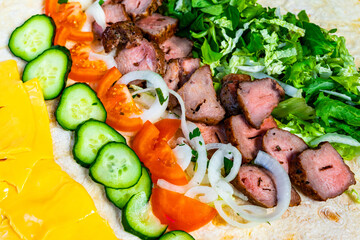 Freshly prepared burrito filled with grilled meat and vegetables