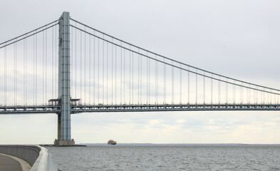 large shipping container ship arriving in new york city harbor under the verrazzano narrows bridge (nyc waterway delivery overseas tariffs) containers